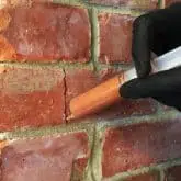Picture showing cracked brick being repaired with crack injection mortar