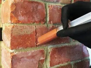 Picture showing cracked brick being repaired with crack injection mortar
