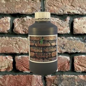 Bottle of Black Mortar Tint against brick wall