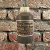 Bottle of Harvest Brown Mortar Tint against brick