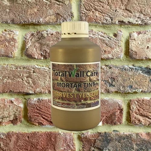 Bottle of Harvest Yellow Mortar Tint against brick wall