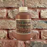 Bottle of Red Mortar Tint against brick wall